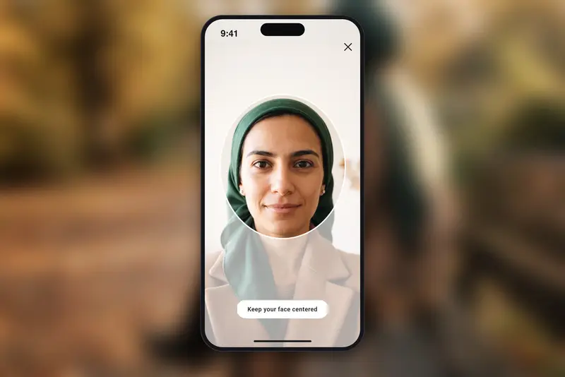 The live selfie check screen on the Habiboo app, showing a Muslim woman in a green headscarf centred in the oval guide